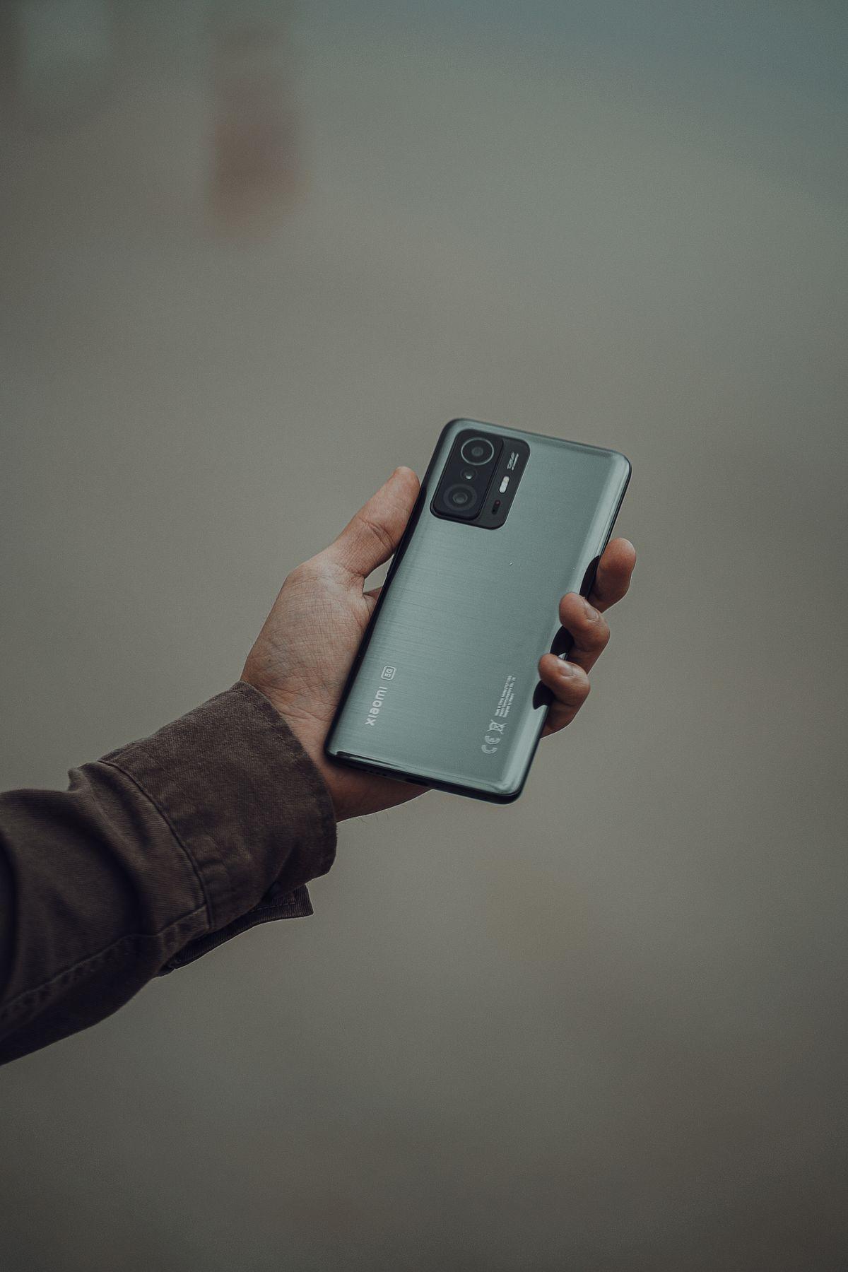 手にスマートフォンを持つ人、通信状況を確認するイメージ